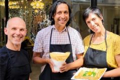 Couple proudly showing the crepes they made during a crepe making class at Disco Crêpes in Paris.